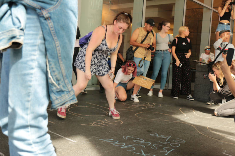 Youth stopped at the San Francisco offices of BlackRock, Inc., to write slogans like "You are the problem" in chalk on the sidewalk. 