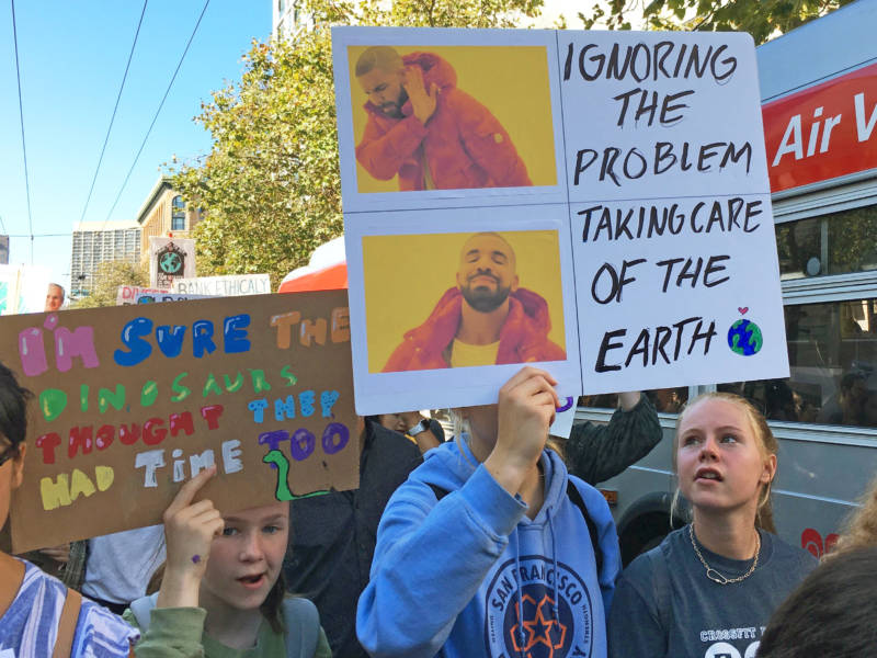 Lis Ana Johansen, 13, of San Francisco, holds a poster she made using a Drake meme to call for more urgent action on climate change during a youth-led march on Sept. 20, 2019.
