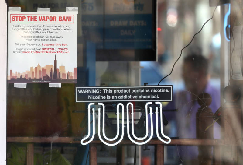 A neon sign advertising Juul e-cigarettes is displayed in a window of a tobacco store on June 25, 2019 in San Francisco. The San Francisco Board of Supervisors voted unanimously, 11-0, to be the first city in the United States to ban e-cigarettes, nicotine pods and devices that have not been approved by the Food and Drug Administration.