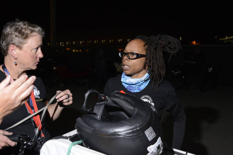 Tamar V. Jeffery talks to another woman next to a motorcycle.