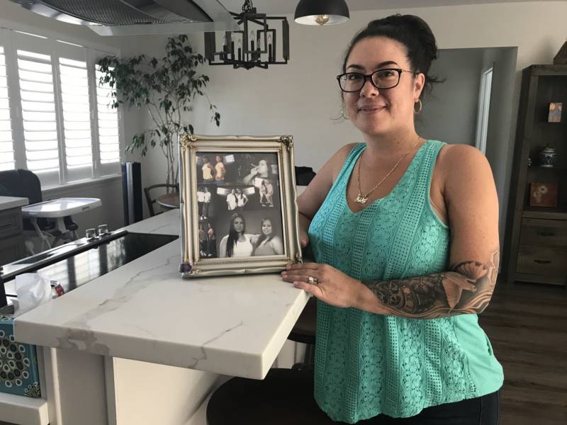 Amika Mota poses for a portrait at her home in the San Francisco Bay Area on Sept. 26, holding a framed collage of her 'prison family.'