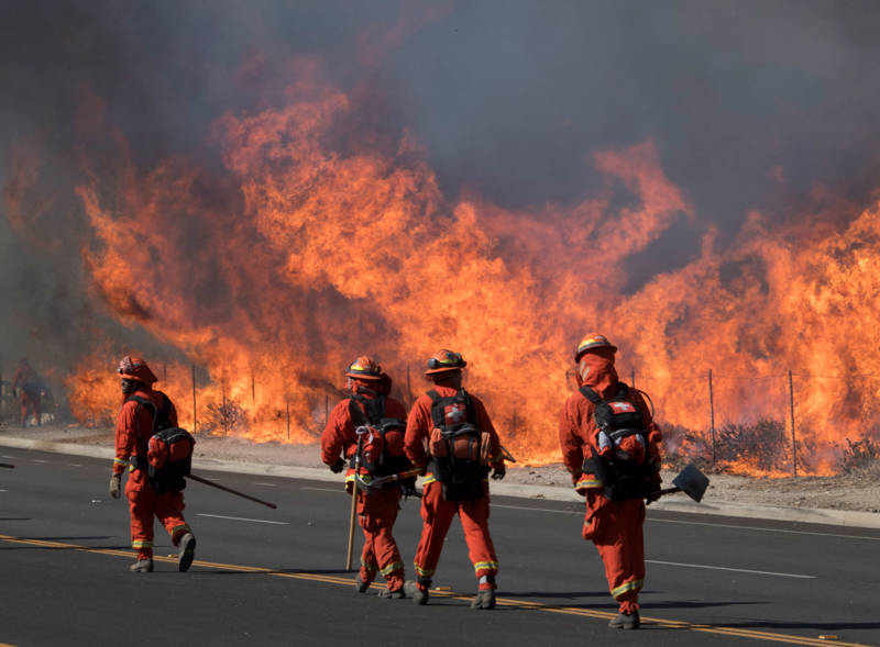 Inmate firefighters prepare to put out flames on the road leading to the Reagan Presidential Library during the Easy Fire in Simi Valley on Oct. 30, 2019.