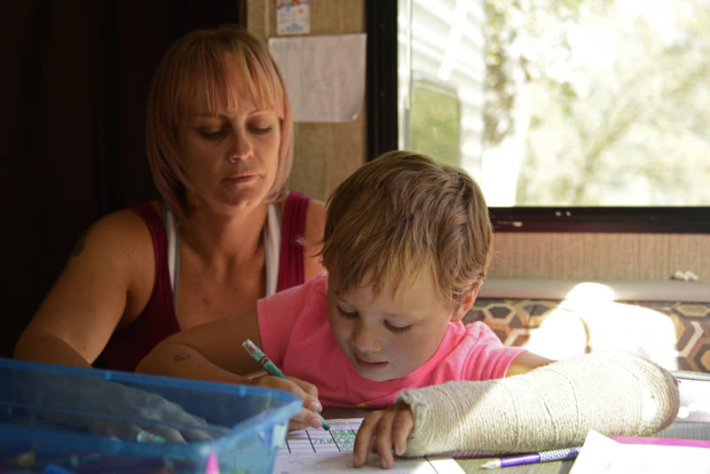 Sabrina Hanes home schools her daughter Aroara in their trailer on October 7, 2019 outside Paradise, Ca where their home was destroyed in the 2018 Camp Fire.