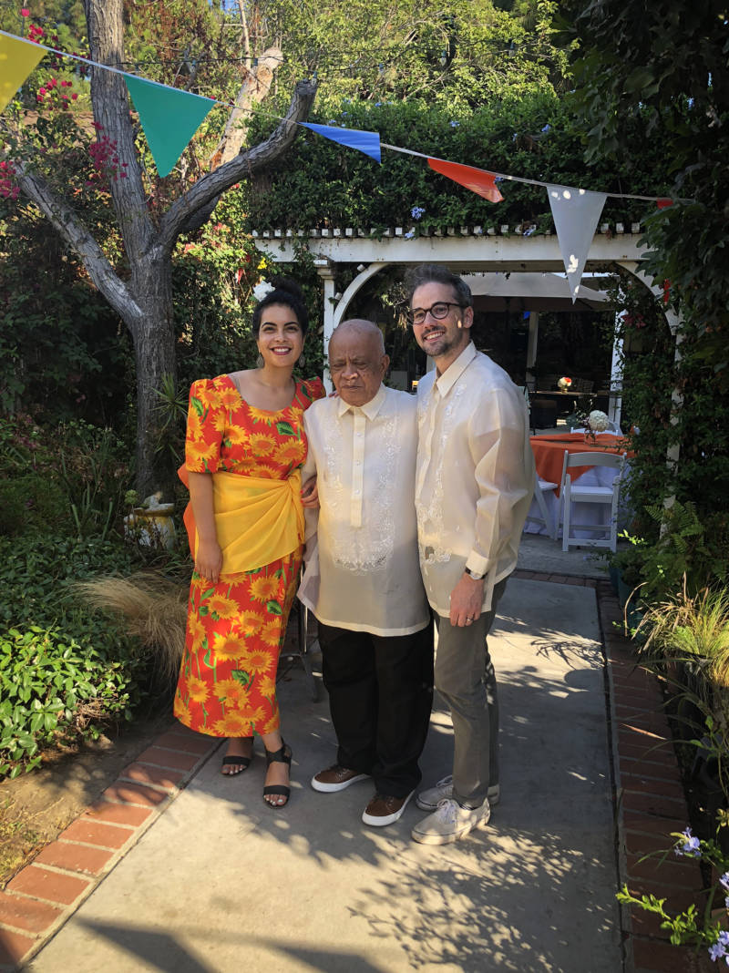 Malaka Gharib, her grandfather Floro Mercene and her husband, Darren Vandergriff, wear traditional Filipino clothing at her grandfather's birthday party.
