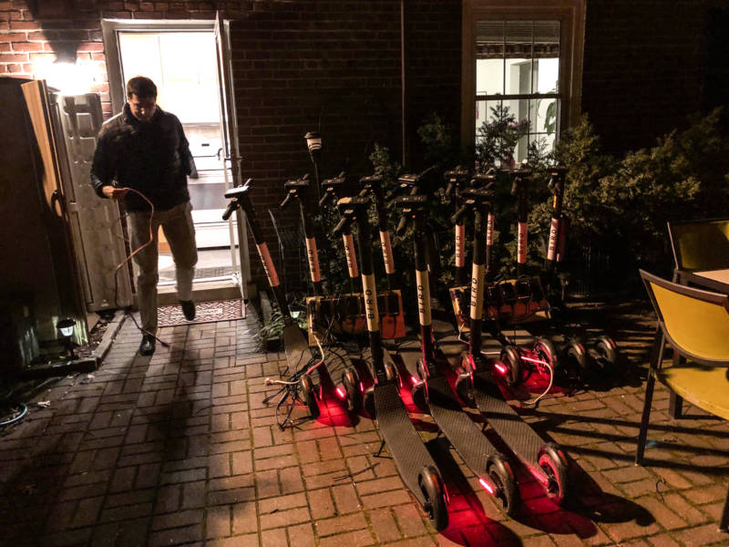 Joel Kirzner charges Bird scooters on his patio in Arlington, Va., on March 4. He routinely picks up scooters after his workday is finished and charges them overnight for the companies Bird and Lime.