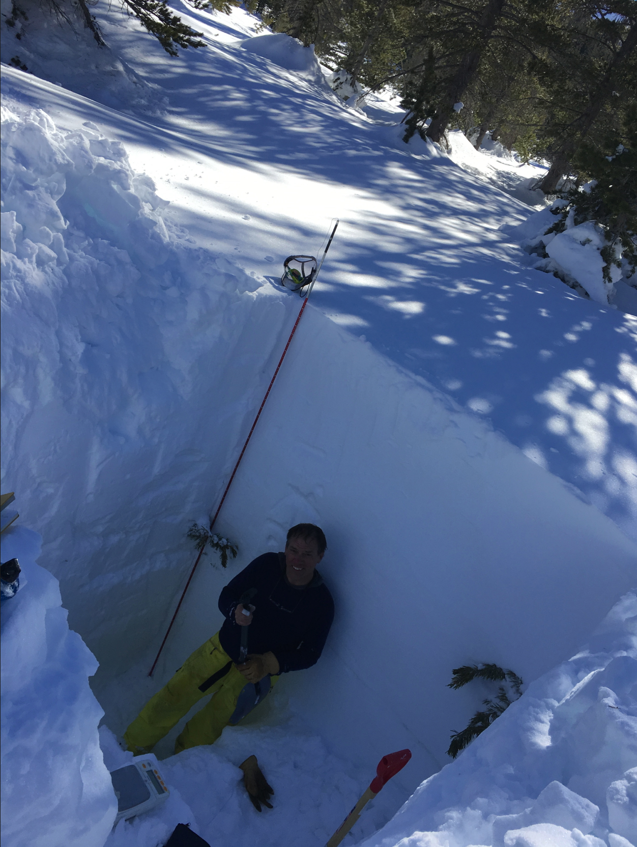 Snow hydrologist Tom Painter takes a break after digging out a snow pit, to measure density and other parameters.