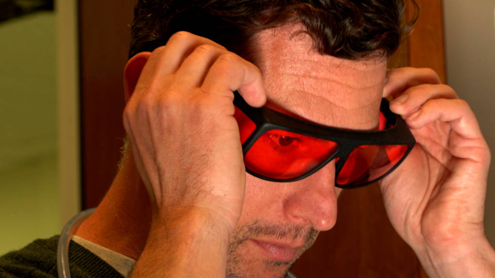 At Caltech, neuroscientist Eric Hoopfer puts on special glasses to protect his eyes from the red light he will flash on his research fruit flies. 
