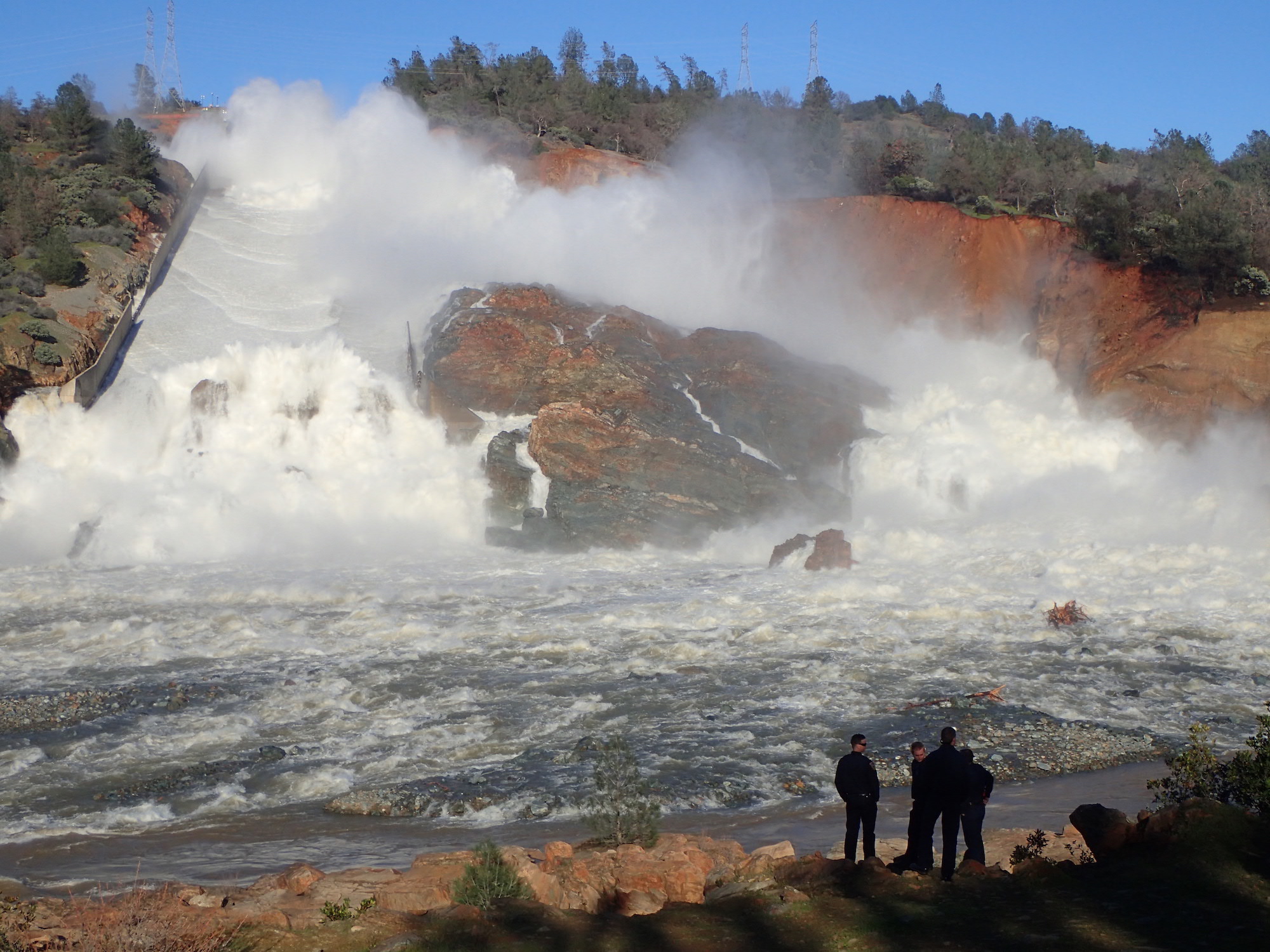 A Cal Fire crew watches as water roars down Oroville's main spillway at 100,000 cubic-ft. per second.