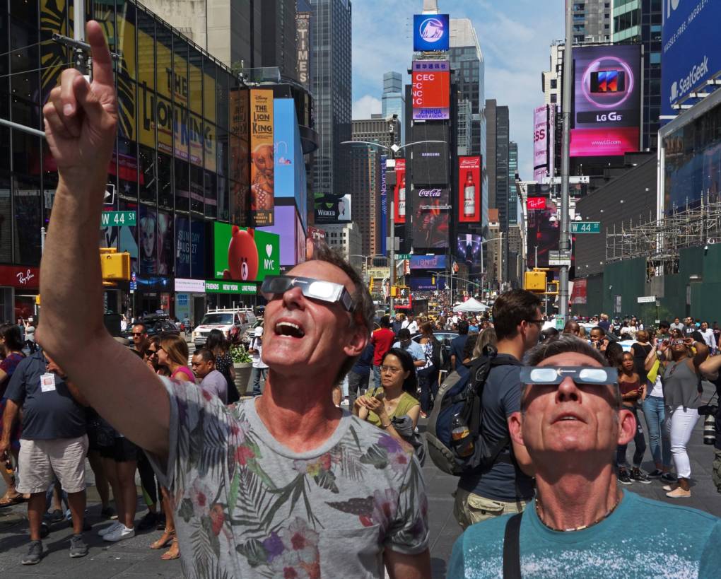 Thousands flocked to Times Square in New York City to view the partial eclipse. Emotional sky-gazers stood transfixed across North America Monday as the Sun vanished behind the Moon in a rare total eclipse that swept the continent coast-to-coast for the first time in nearly a century.