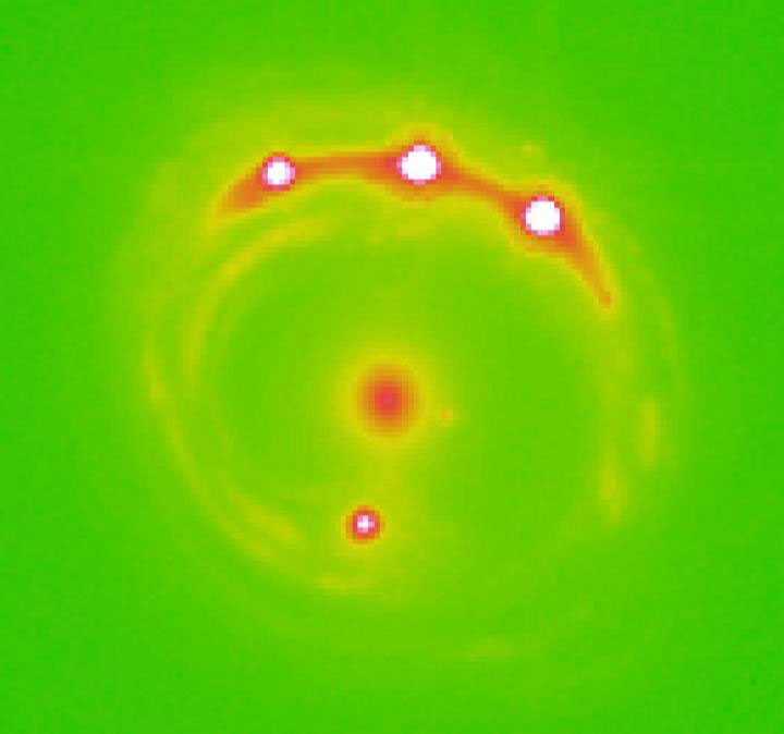 Gravitational lens image captured through the Chandra X-ray Observatory. At center is the intervening elliptical galaxy, which is acting as the gravitational lens producing four magnified images (surrounding) of the background quasar RX J1131-1231. The host of exoplanets within the central elliptical galaxy were detected by their microlensing of the background quasar's X-ray emissions. 