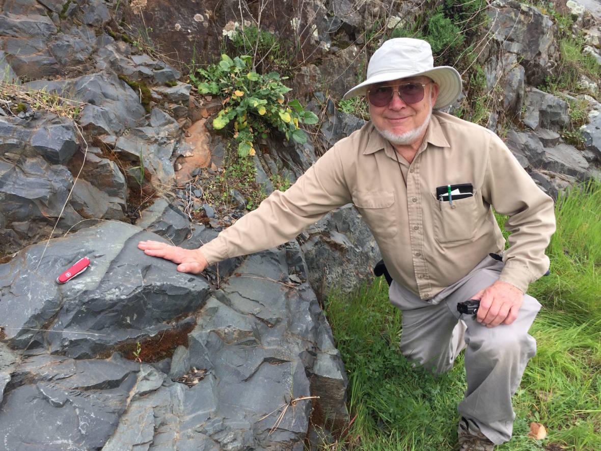 Eldridge Moores in one of the road cuts where rocks reveal the origins of the Sierra Nevada. (Craig Miller/KQED)