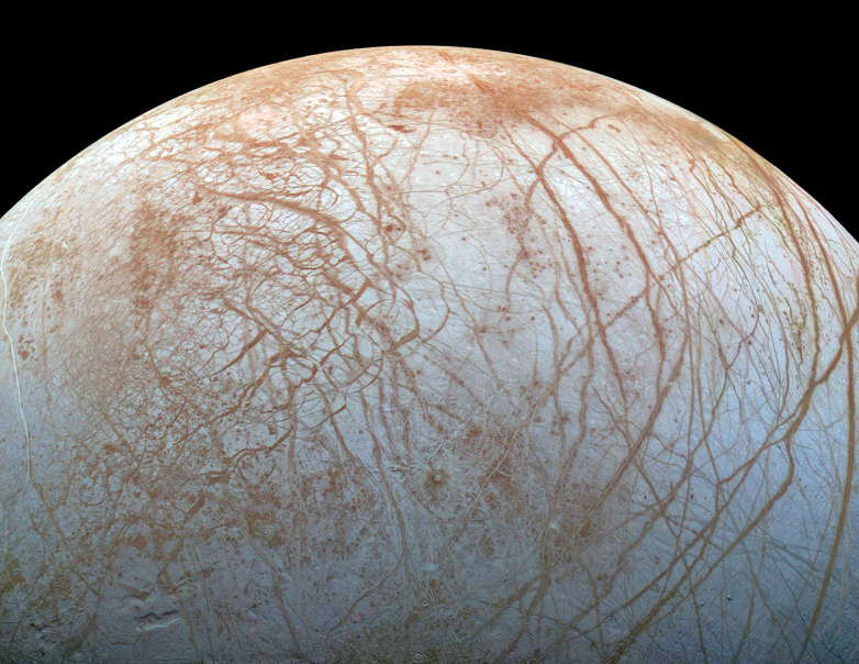 Jupiter's moon Europa, as photographed by the Galileo spacecraft. The pattern of cracks in the icy crust indicates that it floats on an ocean of liquid water. 
