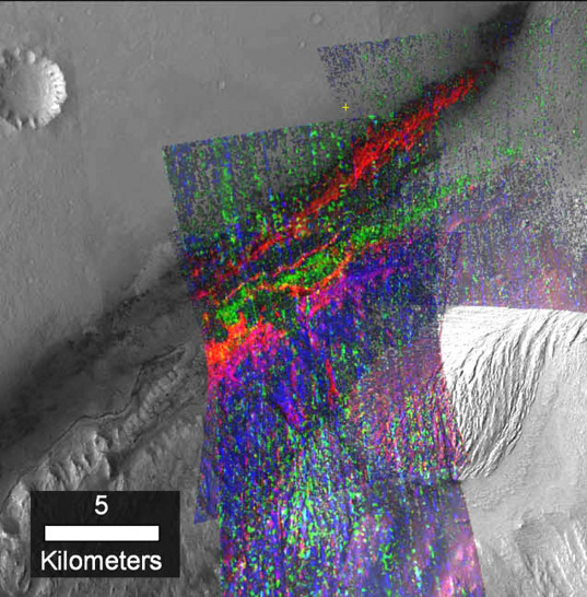 A mineral map of the slopes of Mount Sharp being explored by NASA's Curiosity rover, made from data from the Mars Reconnaissance Orbiter's CRISM instrument. A cross marks the original 2012 landing site of the Curiosity rover. Green indicates clay minerals that may have been deposited in the deep water's of the lake, while blue and magenta indicate sulfates formed when lake waters were drying up. 