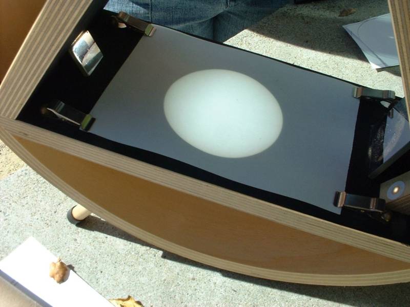 Magnified images of the sun may be projected onto a white surface, either with a small telescope or a specially designed sun-projecting instrument, such as the "Sunspotter" depicted in this image. 