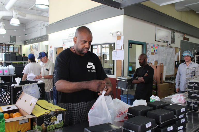 Production manager Will Matthews bags Project Open Hand’s meals and groceries for delivery.